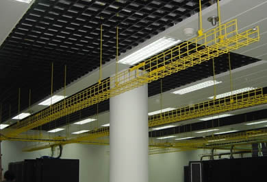 Yellow powder coated basket cable trays are installed on the roof in interior computer server room